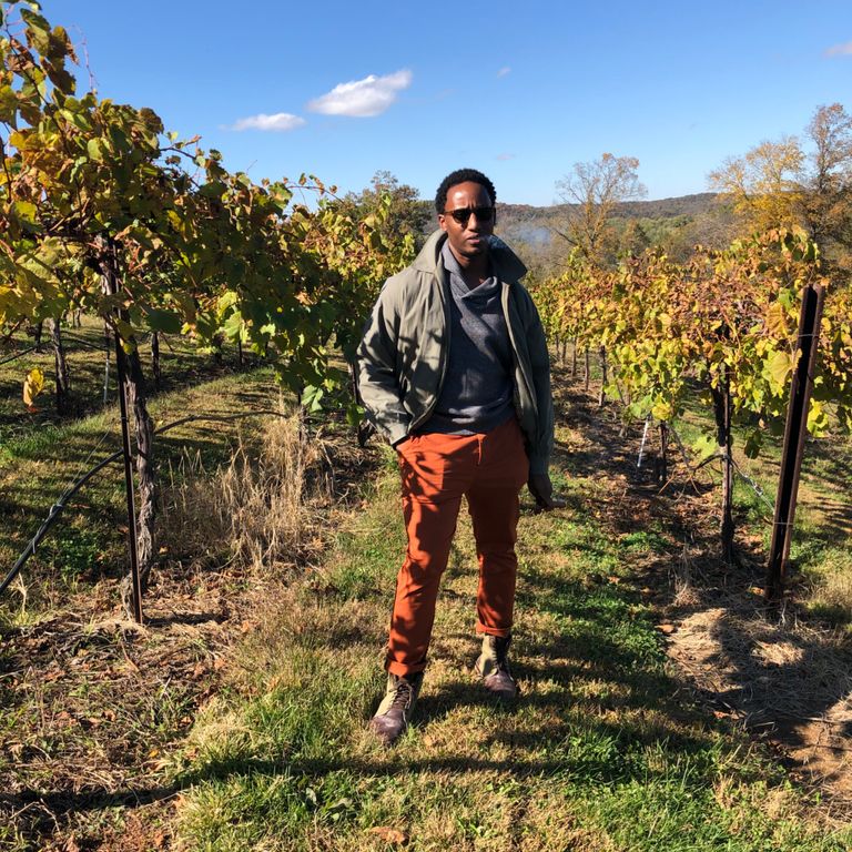 Nashad Carrington standing amongst grape vineyards in the Spring.